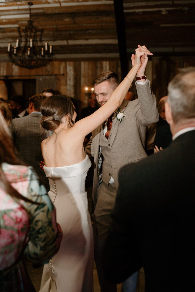 a bride and groom dancing together in the middle of a packed dance floor of guests at Botley Hill Barn, a luxury wedding venue in Surrey