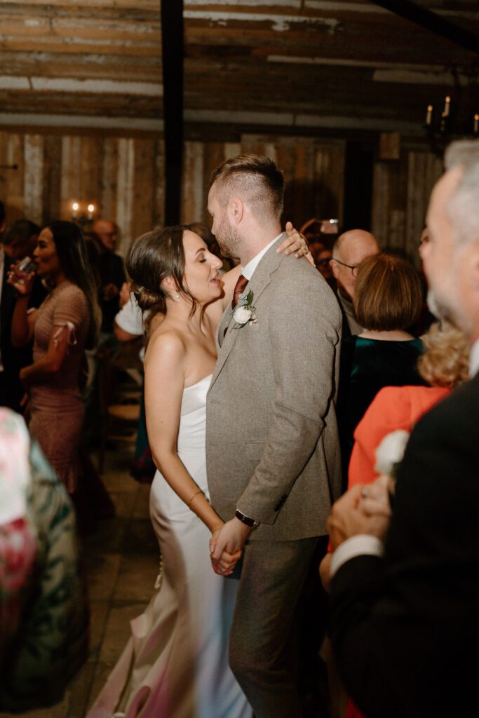 a bride and groom dancing together in the middle of a packed dance floor of guests