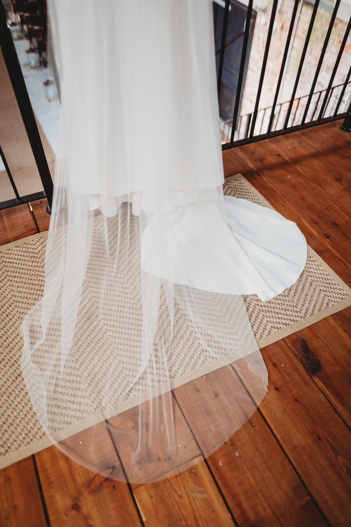 the bottom detail of a wedding dress, hung ready for the day