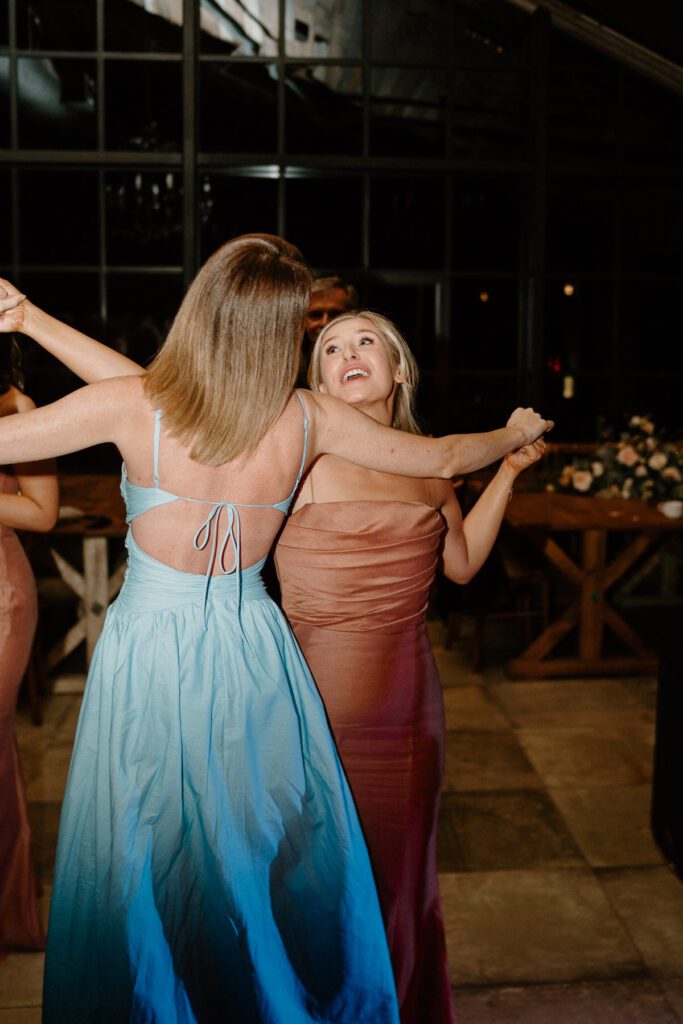 two wedding guests dancing and singing together at a wedding reception at Botley Hill Barn in Surrey