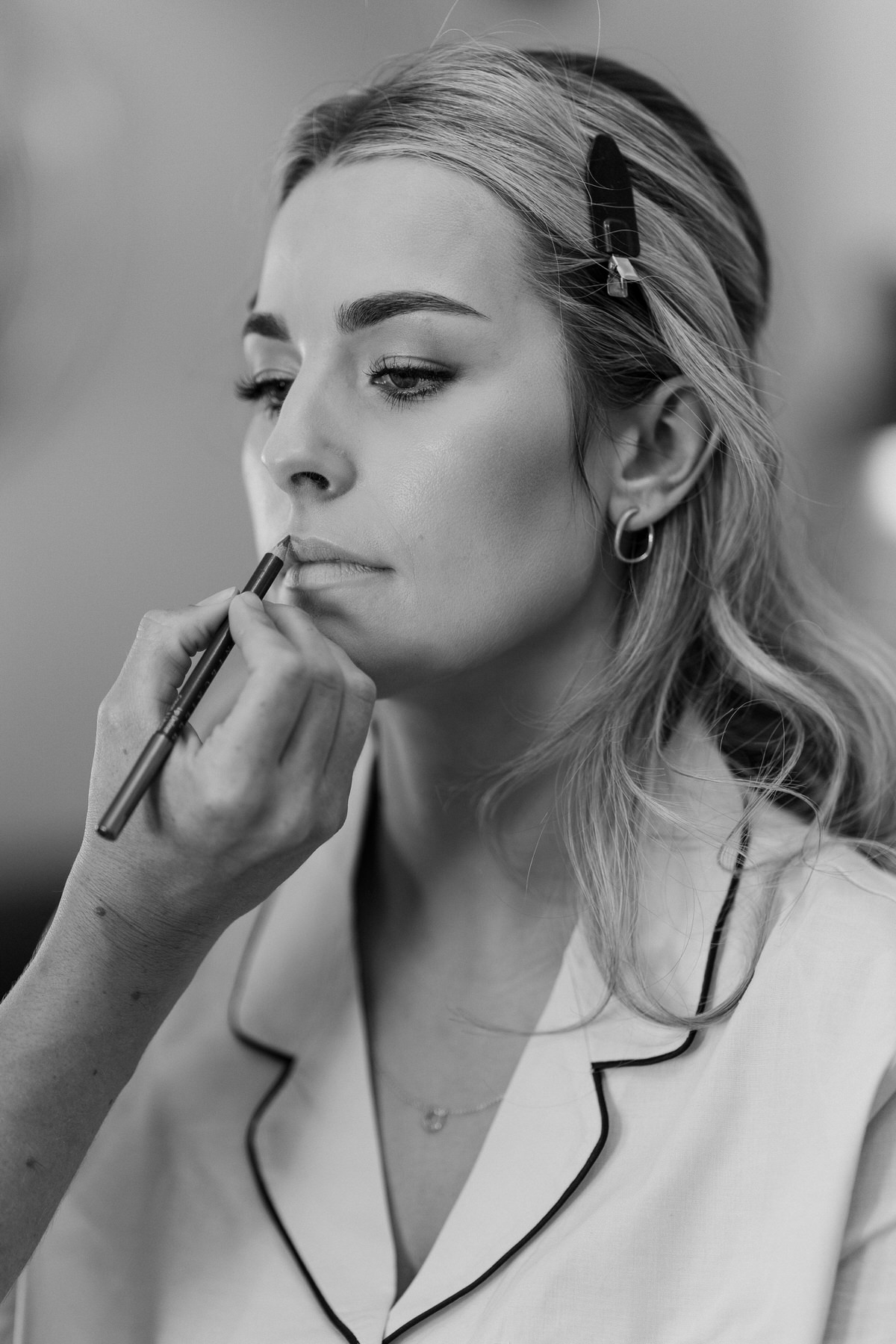 a bridesmaid having the final touches of her make up finished during bridal prep at a surrey wedding venue