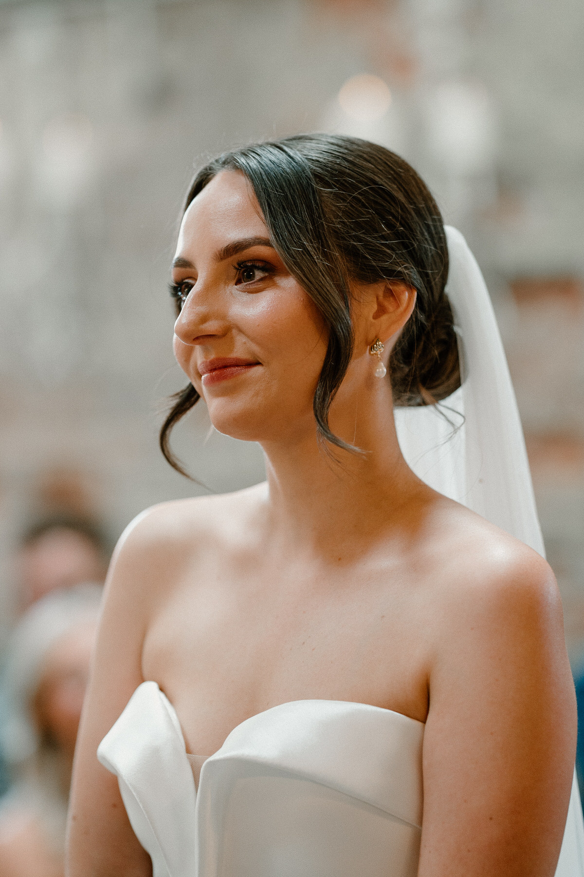 a bride looks t her husband to be, thoughtfully as they stand for the wedding ceremony