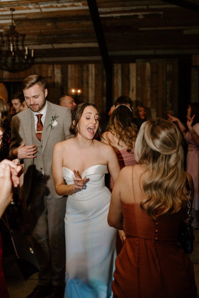 a photo of a bride singing and dancing during her wedding reception taken by a luxury wedding photographer