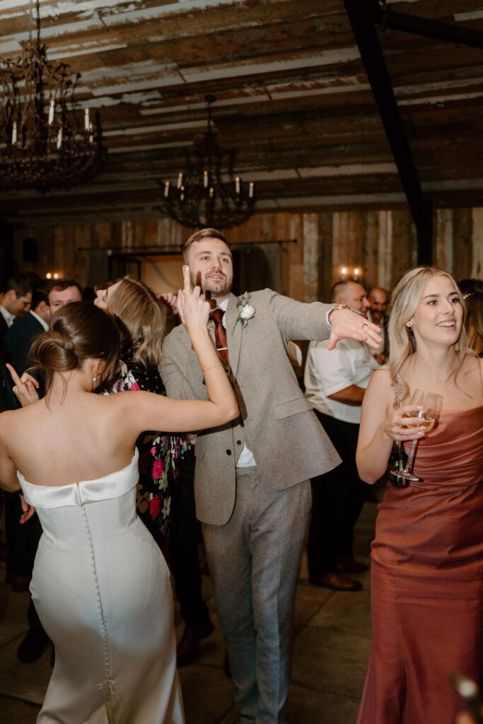 a bride and groom dancing with her guests at their wedding reception at Botley Hill Barn in Surrey