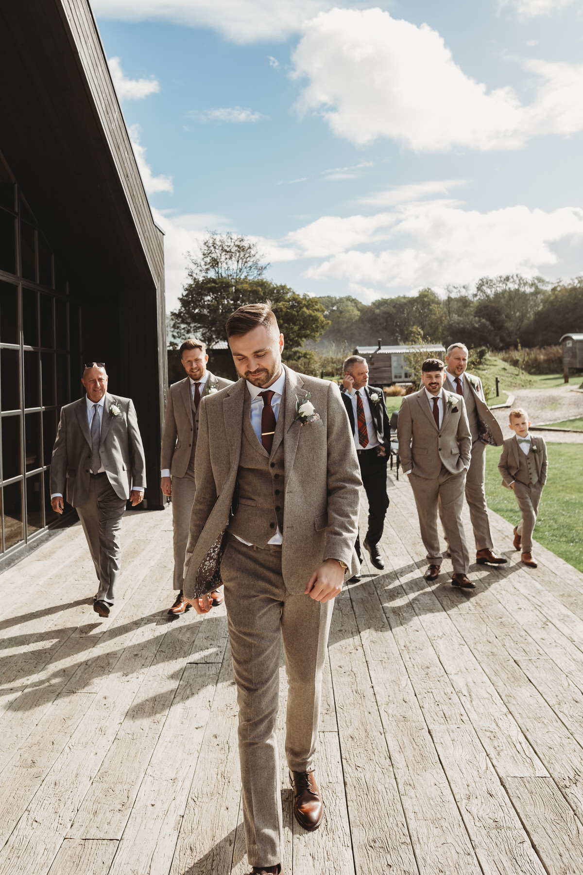 a groom leds the way as his groomsmen follow behind before his wedding