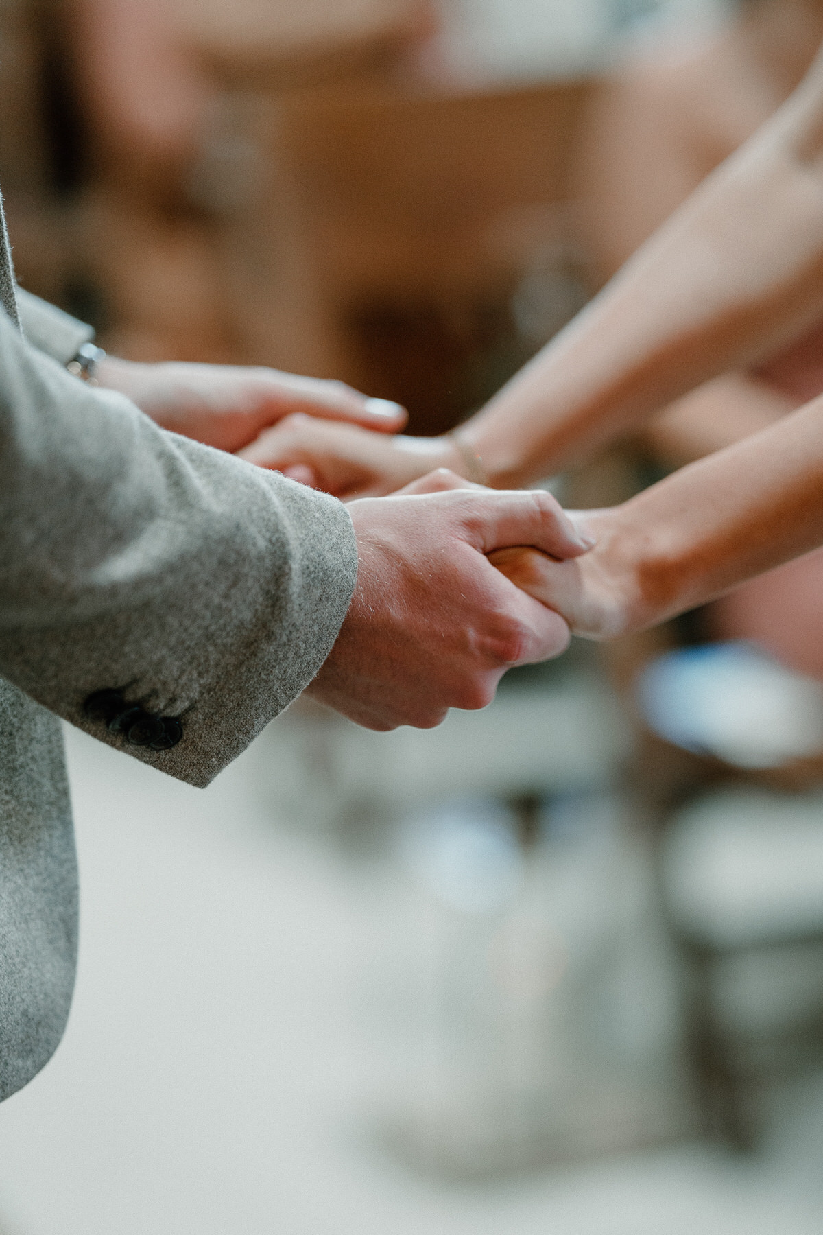 a close up of a bride and groom holding hands as they get married