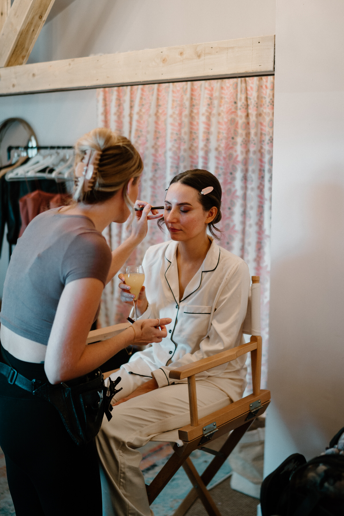 a bride getting the finishes touches of her make up finished during bridal prep