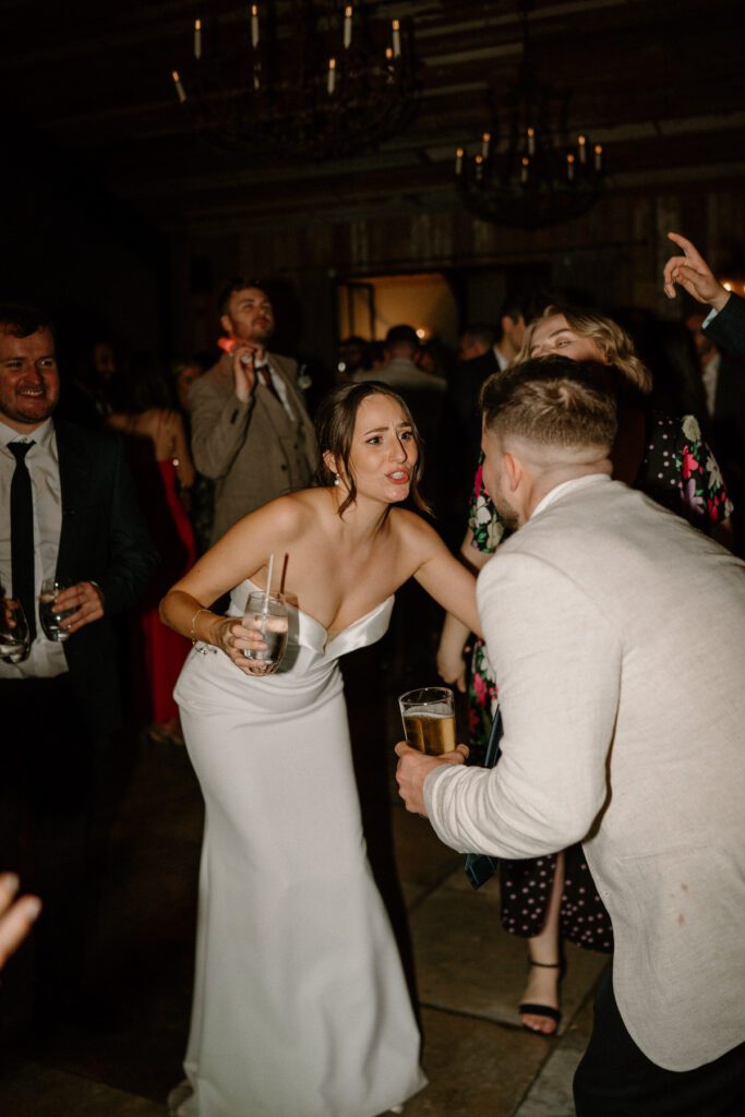 a bride dancing and singing with her guests at her wedding reception taken by a luxury wedding photographer at Botley Barn Hill 