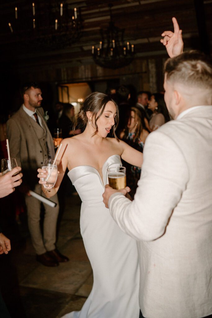 a bride dancing and singing with her guests at her wedding reception taken by a luxury wedding photographer at Botley Barn Hill 