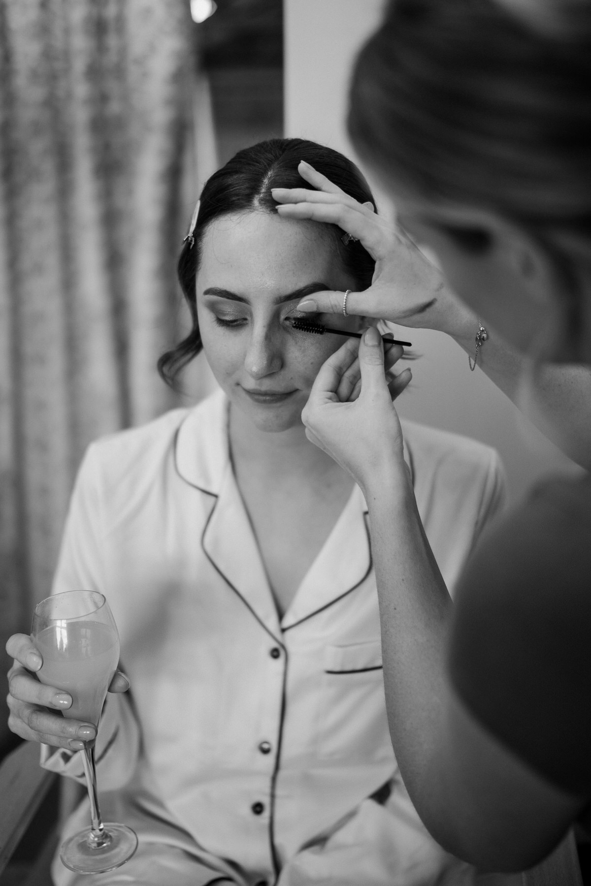 a bride having her make up finished ready for her luxury barn wedding in Surrey