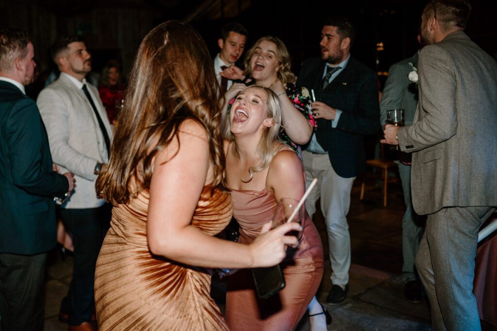 a bridesmaid singing away with the wedding guests at a reception party at Botley Hill Barn, a luxury wedding venue in Surrey