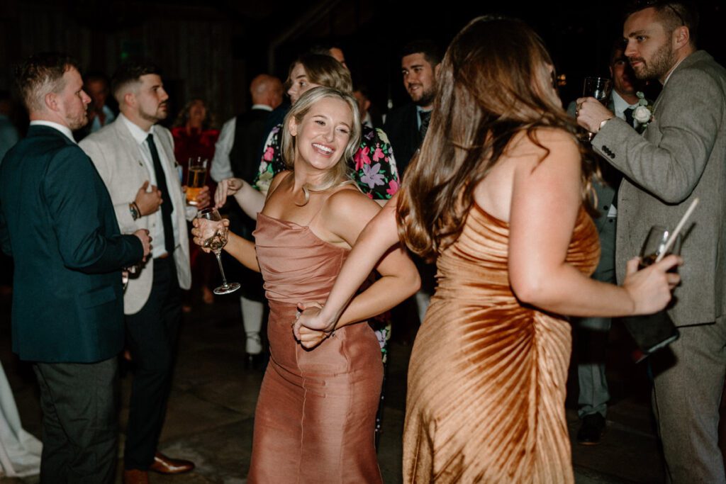 a bridesmaid dancing with wedding guests at a Botley Hill Wedding venue in surrey