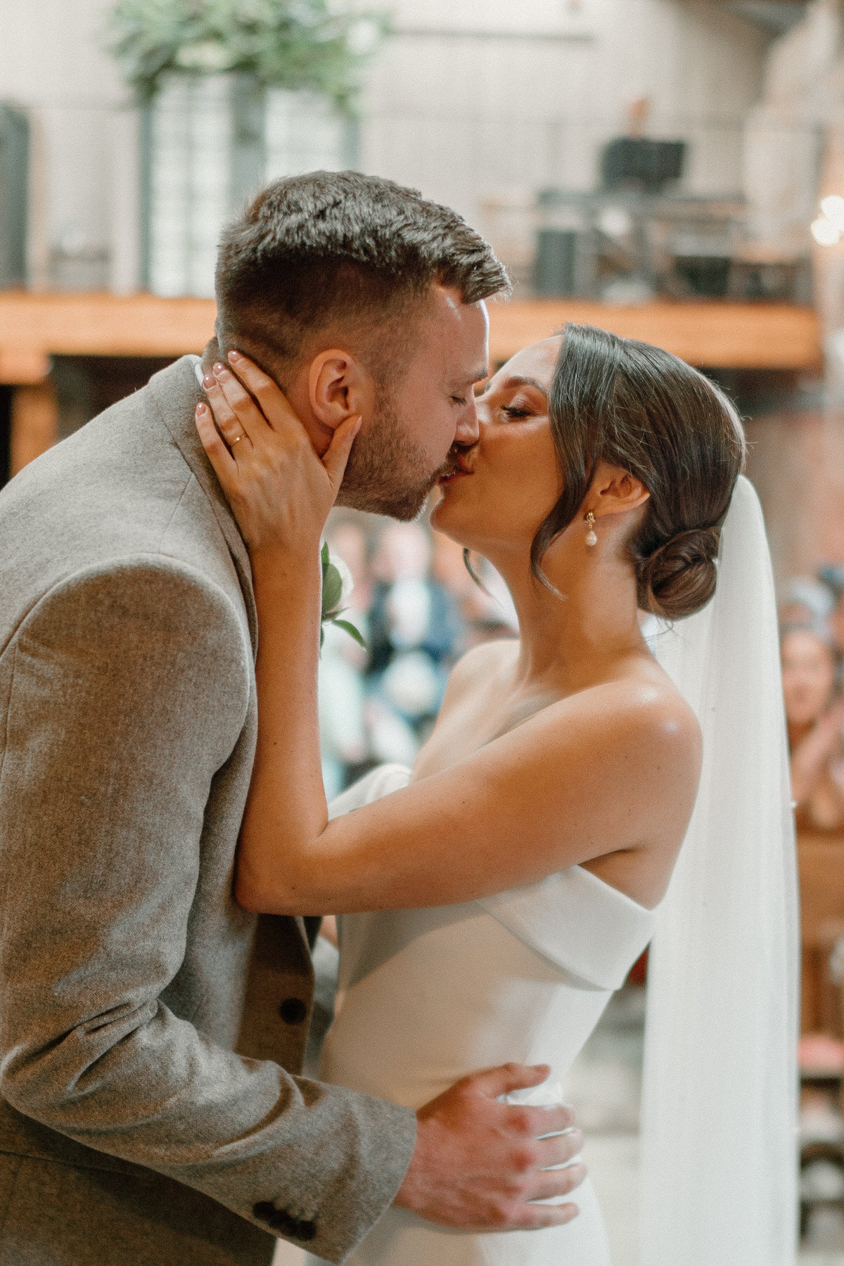 a bride and grooms first kiss after they got married at a luxury surrey barn