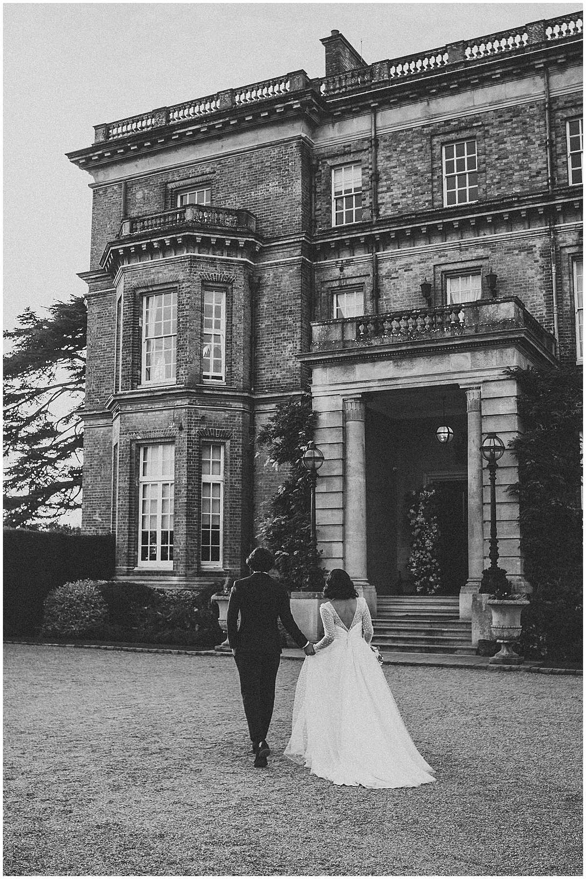 a bride and groom walking back to their wedding venue after their london wedding 