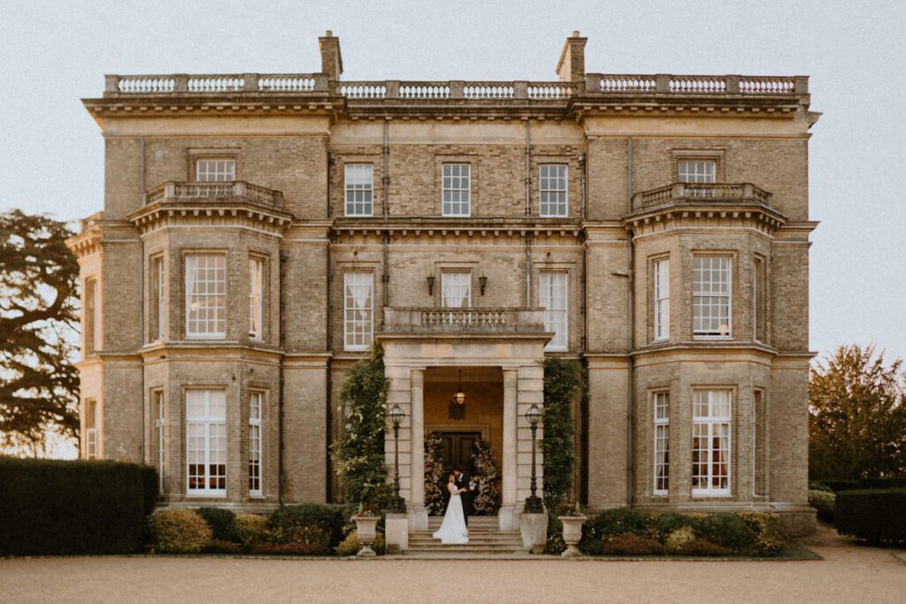 a newly married couple walking out of Hedsor House a luxury wedding venue