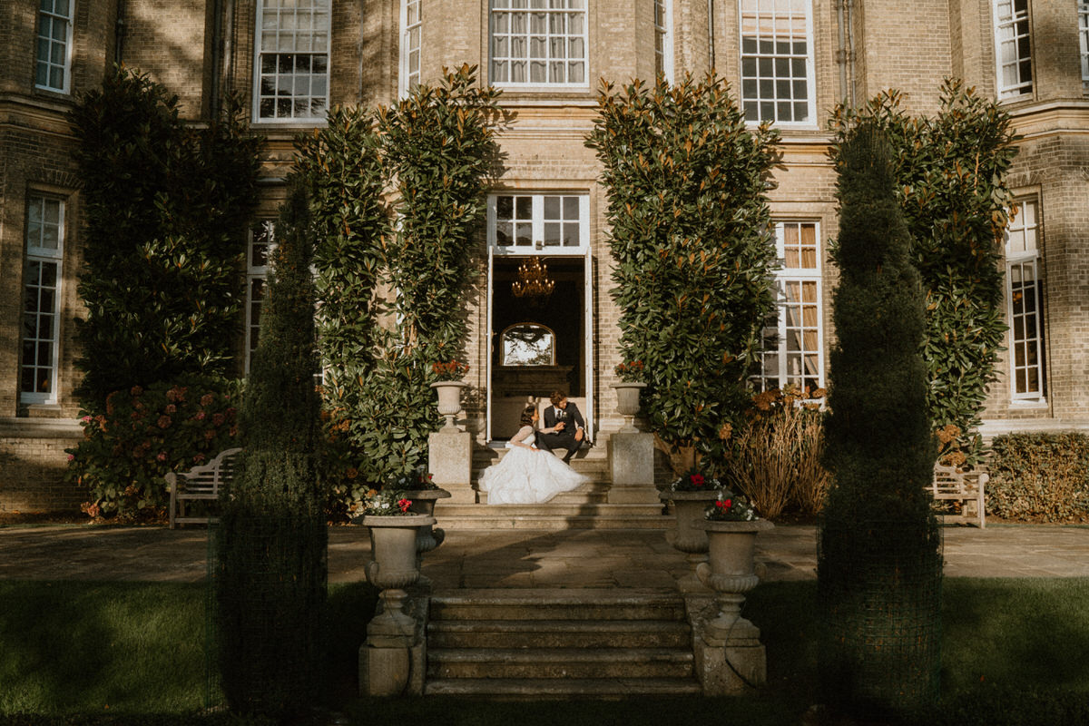 A newly marred couple enjoying the sun on the steps of their wedding venue