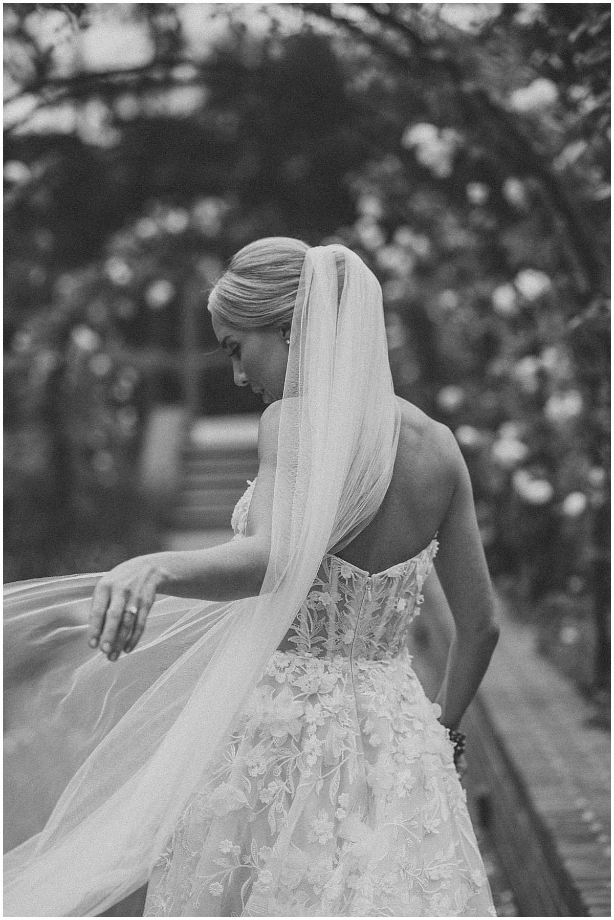 Black & white bridal portrait of the back detailing of the bride with her veil and dress